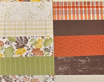 May include: A collection of patterned paper sheets with autumn-themed designs. The sheets feature various patterns, including leaves, plaid, and textured backgrounds in shades of orange, brown, green, and cream. Ideal for scrapbooking and crafting projects.