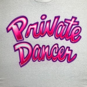 May include: White t-shirt with the words "Private Dancer" written in pink and purple letters with a 3D effect.