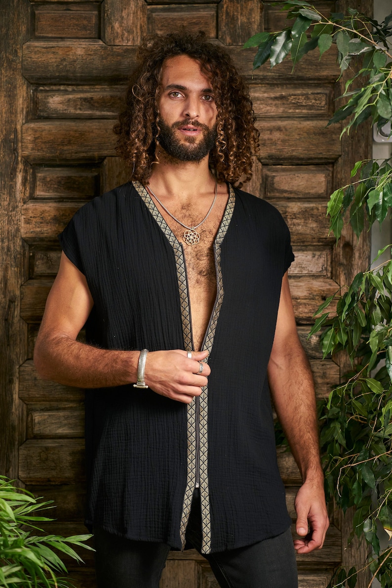 Pode incluir: Uma camisa preta sem mangas com um z&iacute;per na frente e detalhes dourados. A camisa &eacute; feita de um tecido macio e leve e tem um caimento solto.