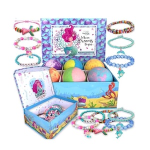 May include: A blue box with a mermaid theme contains six bath bombs and a variety of colorful bracelets. The box lid features a mermaid illustration and the text "Where Dreams Begin..." The bracelets have mermaid-themed charms.