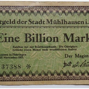 May include: A rectangular green and tan German Notgeld banknote from 1923, featuring the text Notgeld der Stadt Mühlhausen i. Th. and Eine Billion Mark. The bill includes a decorative border, the date 15. November 1923, serial number 37388, and a signature.