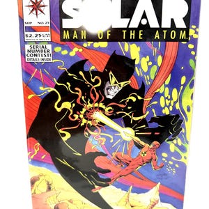May include: A comic book titled Solar Man of the Atom number 25, published by Valiant. The cover features a large black silhouette figure with yellow goggles facing a red-clad character emitting a yellow energy beam against a purple background.