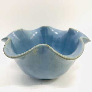 May include: A light blue ceramic bowl with a ruffled edge.