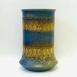 Könnte beinhalten: Eine blaue und braune Keramikvase mit geometrischem Muster. Die Vase hat einen breiten Boden und einen schmalen Hals.