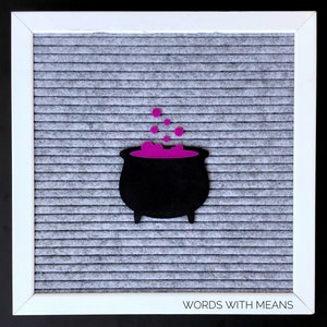 May include: A black felt cauldron with purple felt potion and bubbles on a gray letter board with the text "WORDS WITH MEANS" at the bottom.