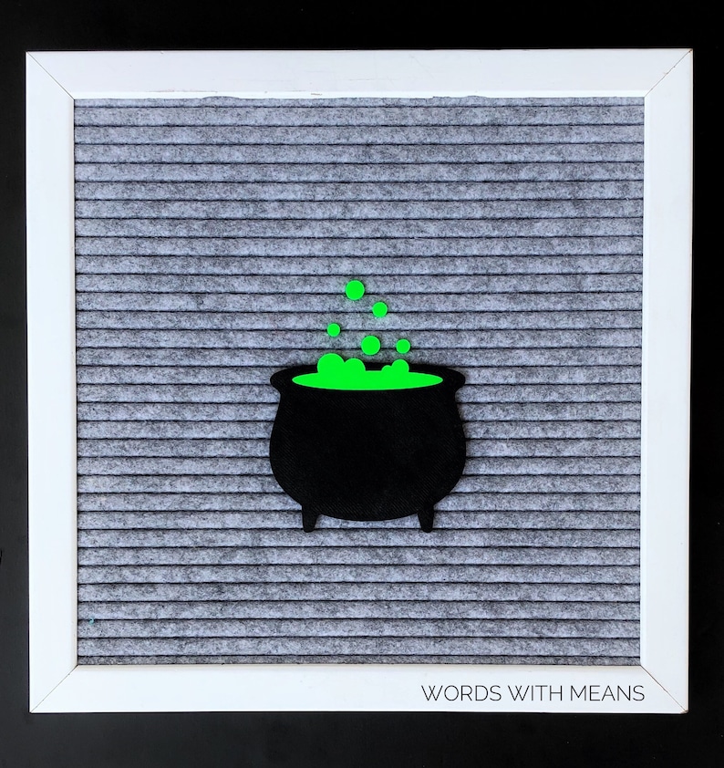 May include: A black cauldron with green bubbling liquid on a gray letter board with the text "WORDS WITH MEANS" at the bottom.
