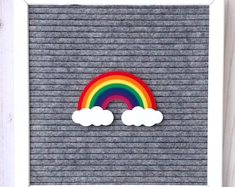 May include: A colorful rainbow with white clouds on a gray felt letter board. The board has a white frame and the text "WORDS WITH MEANS" is printed on the bottom right corner.