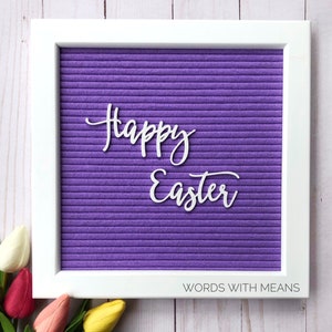 May include: A white letter board with a purple felt background. The words "Happy Easter" are spelled out in white letters.