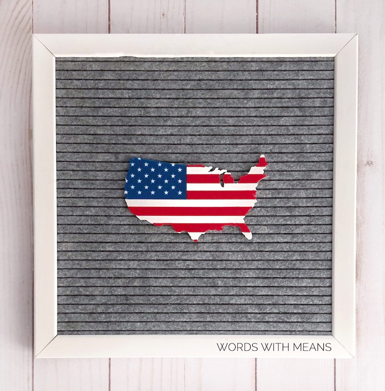 Peut inclure: Un tableau d'affichage blanc avec un fond en feutre gris. Le tableau pr&eacute;sente une d&eacute;coupe des &Eacute;tats-Unis en forme de carte avec le motif du drapeau am&eacute;ricain. Le texte "WORDS WITH MEANS" est imprim&eacute; en bas du tableau.