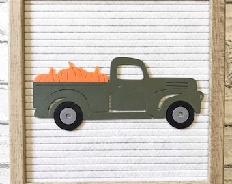 May include: A green vintage pickup truck with a bed full of orange pumpkins. The truck is on a white background with the words "WORDS WITH MEANS" at the bottom.