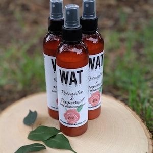 May include: Three brown glass bottles with spray tops, labeled "WAT with a twist Rosewater & Peppermint Daily Moisturizing Spray 2 oz www.withatwistnhc.etsy.com".