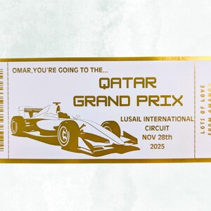 Pu&ograve; includere: Un biglietto dorato con la scritta "QATAR GRAND PRIX" e un'illustrazione di un'auto da corsa. Il biglietto recita "OMAR, YOU'RE GOING TO THE..." e "HAPPY 50TH BIRTHDAY". Include anche la data "NOV 28th 2025".