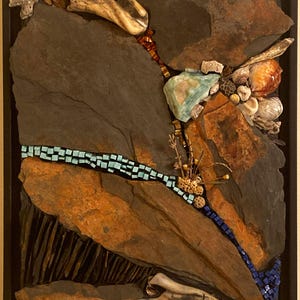 May include: A framed mixed media wall art piece featuring large dark gray and rust-colored slate slabs. The composition includes light blue and dark blue square mosaic tiles, various seashells, bleached bone fragments, and dried plant elements.