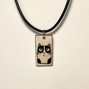Hand-painted and varnished wooden cat pendant.