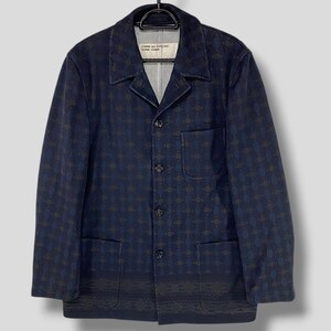 May include: Navy blue jacket with a repeating geometric pattern. The jacket has a notched collar, three buttons, and two front pockets. The brand name is visible on the inside of the jacket.