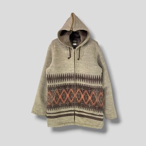 May include: A beige hooded zip-up jacket with a geometric pattern in brown and orange. The jacket has a full zipper, a hood, and two front pockets. The pattern is a repeating design across the front.