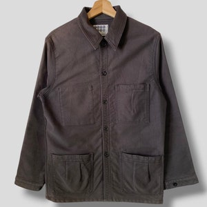 May include: A dark gray long-sleeved work shirt with multiple pockets and a button-up front. The shirt has a brand label with the text "888" and a circle pattern.