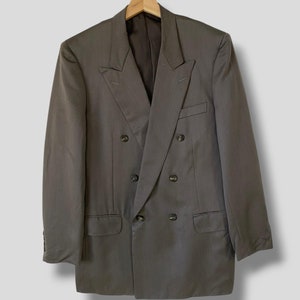 May include: A grey double-breasted blazer with a notch lapel and six buttons.