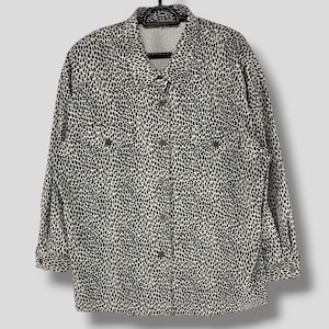 May include: A white long-sleeved button-up shirt with a black leopard print pattern.