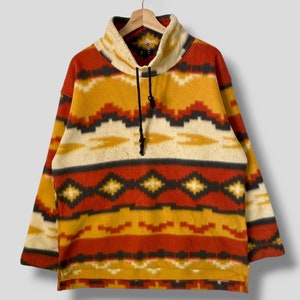 Puede incluir: Un jersey de forro polar con cuello alto y cordón de ajuste, con un patrón rojo, amarillo y negro.
