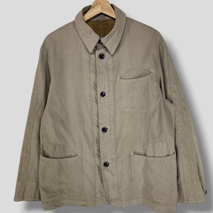 May include: A beige linen work jacket with a button-up front, two chest pockets, and two lower pockets. The jacket has a collar and long sleeves.