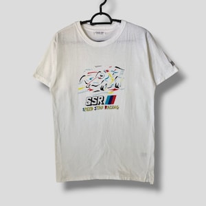 Puede incluir: Camiseta blanca con un gráfico colorido de un coche de carreras y el texto "SSR Speed Star Racing".