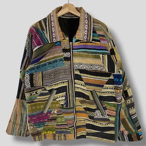 Può includere: Una giacca patchwork multicolore con chiusura a zip. La giacca è realizzata con una varietà di tessuti con diversi motivi e trame. La giacca ha un colletto e due tasche.