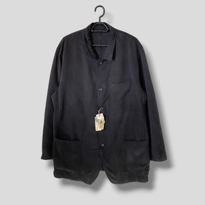 May include: A black long-sleeved button-up jacket with a collar and two pockets. The jacket has a tag attached to it.