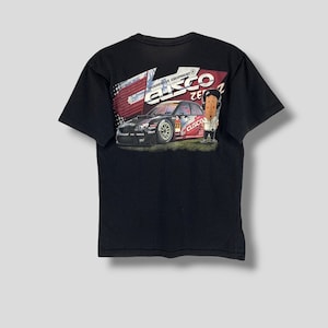 Puede incluir: Camiseta negra con un gráfico de un coche de carreras y el texto "CUSCO". El coche es rojo, negro y blanco. También aparece un personaje de dibujos animados. La camiseta es de material suave.