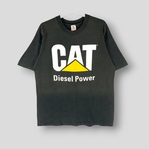 May include: Black t-shirt with the CAT logo in white and yellow, and the words "Diesel Power" in white below the logo. The shirt is hanging on a white hanger.