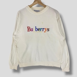 May include: White long-sleeve sweatshirt with a rainbow embroidered "Burberrys of London" logo.