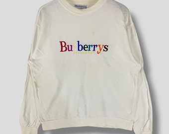 May include: White long-sleeved sweatshirt with a rainbow embroidered "Burberrys of London" logo.