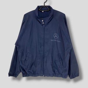 May include: A navy blue windbreaker jacket with a zipper closure and a Mercedes-Benz logo on the front.