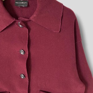 Puede incluir: Una chaqueta de lana color burdeos con cuello, cierre de botones y dos bolsillos de parche. La etiqueta dice "Luciana Zuffi" y "Made in Italy".