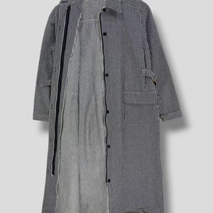 May include: A long-sleeved striped shirt with a button-up front and a zipper closure. The shirt is made of a lightweight fabric and has a relaxed fit.
