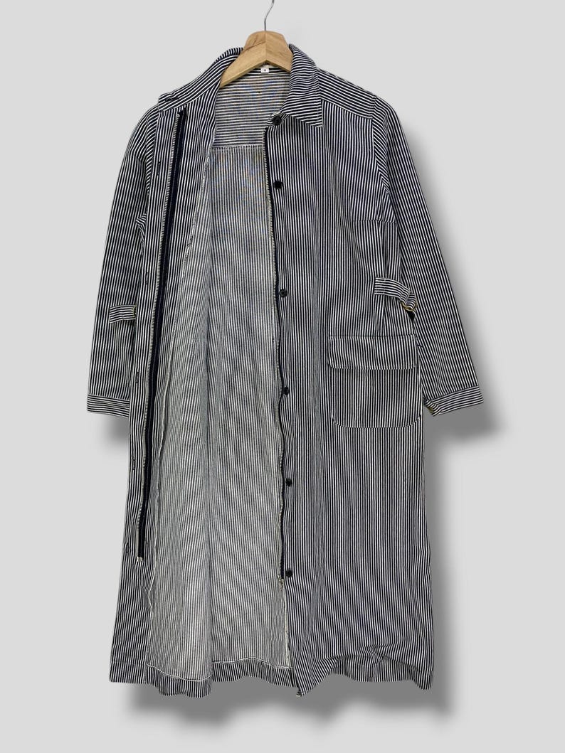 May include: A long-sleeved striped shirt with a button-up front and a zipper closure. The shirt is made of a lightweight fabric and has a relaxed fit.