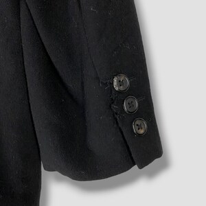 May include: Black blazer with three buttons on the sleeve.