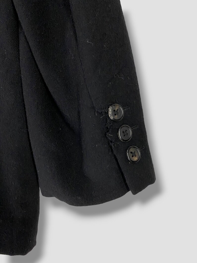 May include: Black blazer with three buttons on the sleeve.