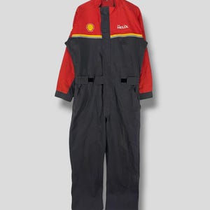 Puede incluir: Mono de trabajo rojo y negro con el logotipo de Shell y el texto "Helix" en el pecho.