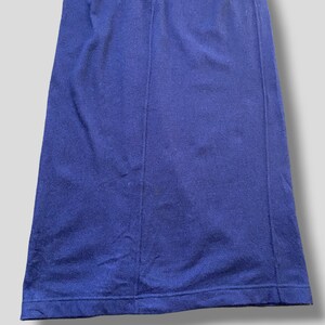 Puede incluir: Primer plano de una falda azul marino. La falda es de color liso y parece estar hecha de una tela suave. La falda tiene una costura en la parte delantera y un dobladillo en la parte inferior.