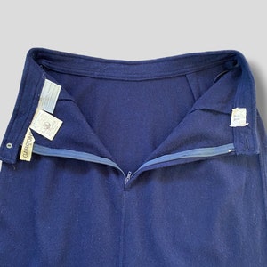 Puede incluir: Falda azul marino con cremallera y bot&oacute;n visibles. La falda tiene un corte recto y un dise&ntilde;o sencillo. La etiqueta de la marca "GARCON" es visible en el lado izquierdo de la cintura. La falda est&aacute; hecha de una tela suave, posiblemente de lana.