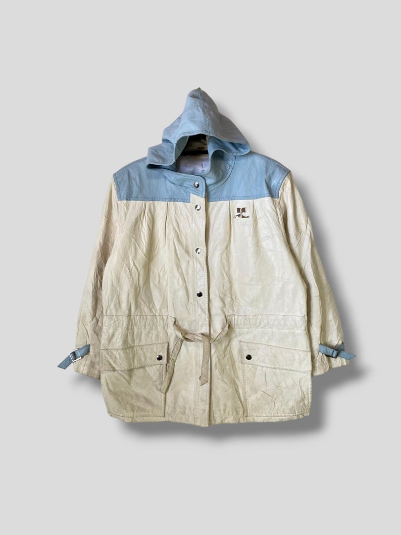 Puede incluir: Una chaqueta con capucha de color crema con capucha y cuello de mezclilla azul. La chaqueta tiene cierre de botones, cintura con cord&oacute;n y dos bolsillos de solapa. La chaqueta tiene un logotipo en la parte delantera que dice "RL".