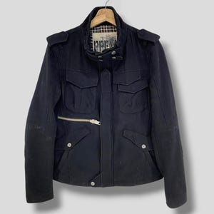 May include: A black wool jacket with a zipper closure and multiple pockets. The jacket has a stand-up collar and a brand label that reads "EPIPHANY".