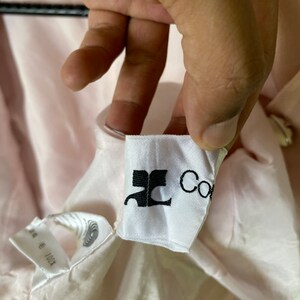 May include: A white tag with black text that reads "JC Collection" on a pink fabric background.