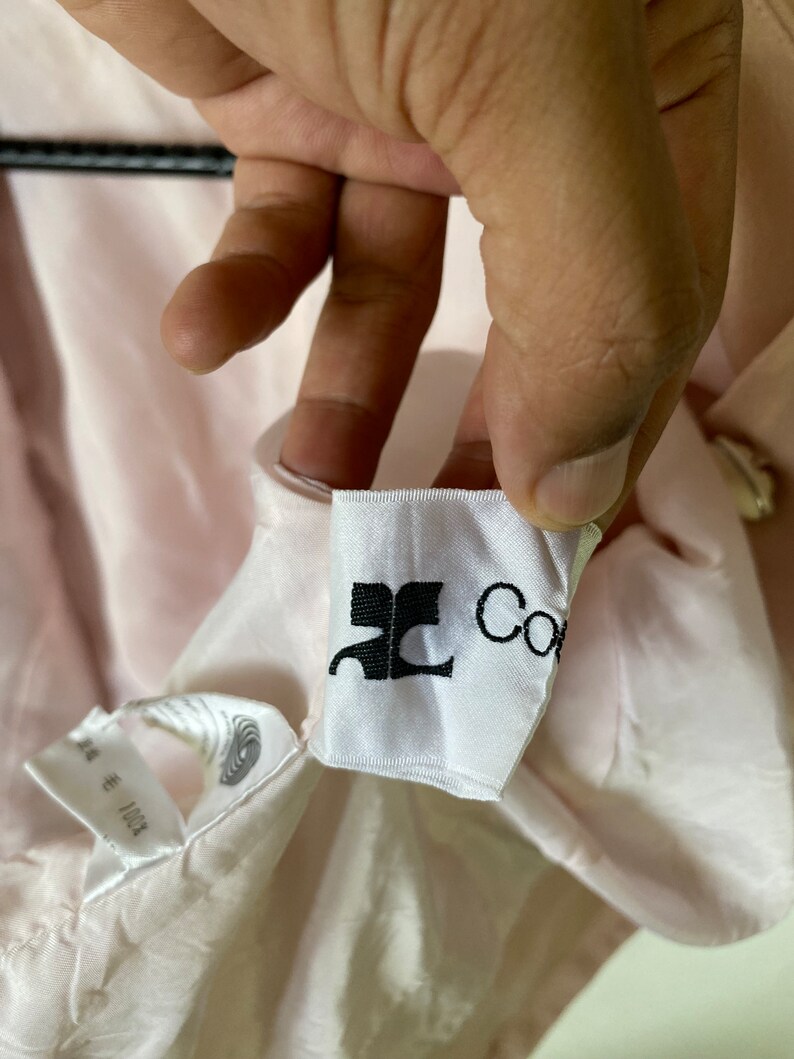 May include: A white tag with black text that reads "JC Collection" on a pink fabric background.