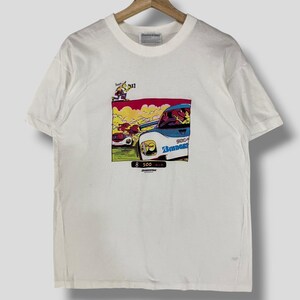 Puede incluir: Camiseta blanca con una ilustración de dibujos animados de un coche de carreras con el texto "Indy 500" y "Compass" en ella.