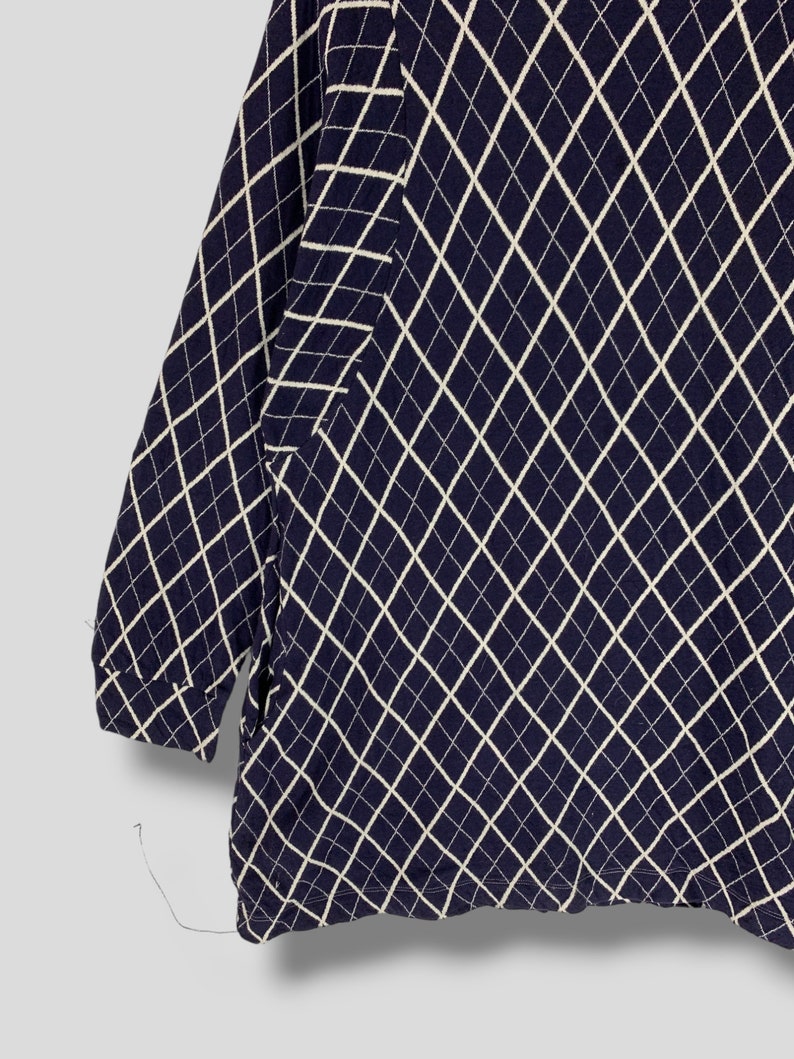May include: Navy blue long-sleeve shirt with a white diamond pattern. The pattern covers the entire shirt, including the sleeves. The shirt is made of a soft, comfortable material.
