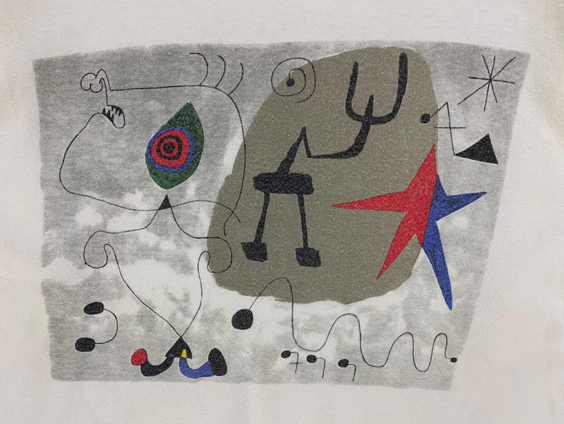 Puede incluir: Impresi&oacute;n de arte abstracto sobre fondo blanco. La obra presenta un fondo gris con una variedad de formas, incluyendo una estrella roja y azul, una figura negra y un dise&ntilde;o en forma de ojo verde, rojo y azul.