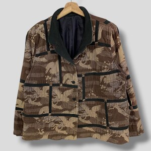 May include: A brown and black patterned jacket with a black collar and a button closure. The jacket has a quilted design and a geometric pattern.