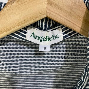 May include: A striped blue and white shirt with a green label that says "Angeliebe" and a size tag that says "9".